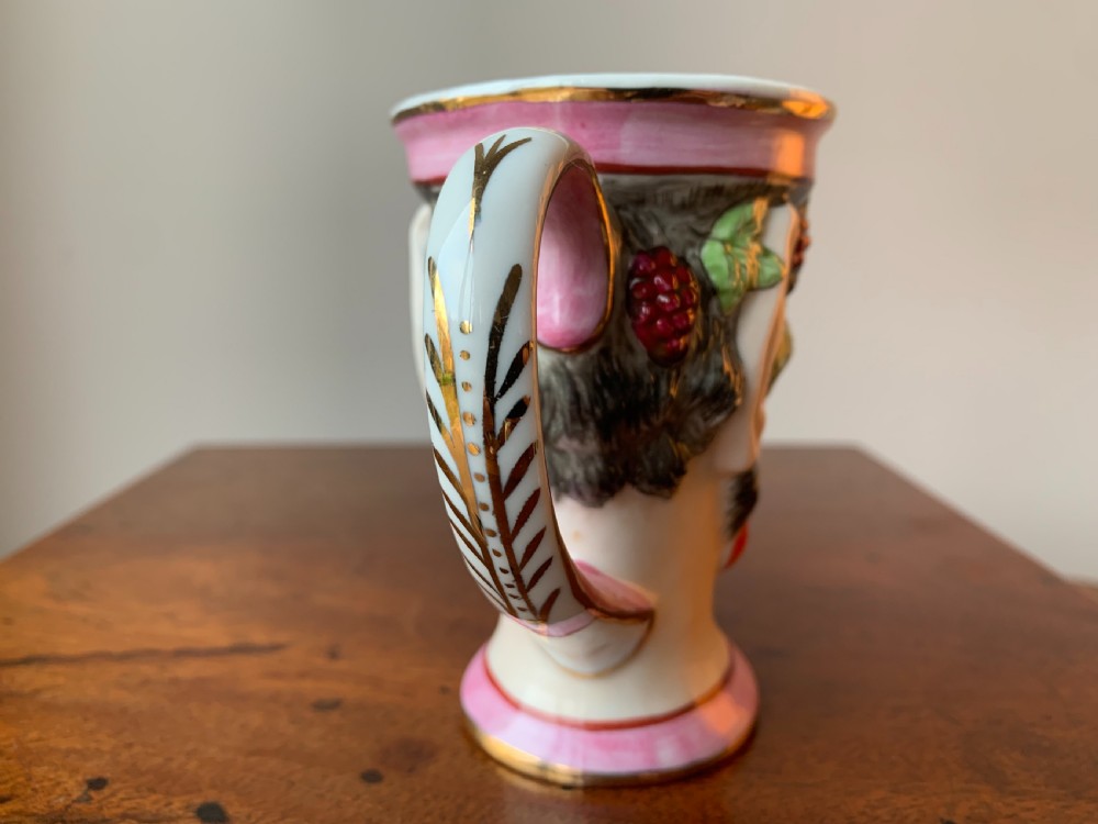 A set of four Victorian Staffordshire ceramic wine cups moulded in the form of bearded satyr faces with grapevine crowns and pink gilded rims. View XII
