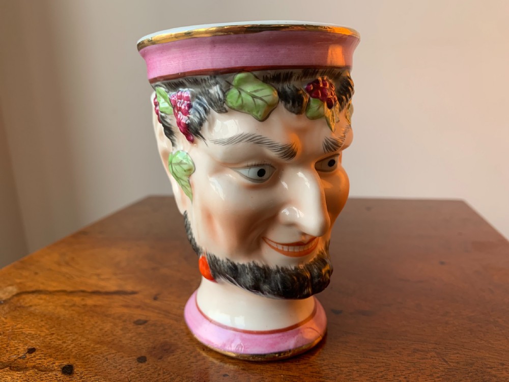 A set of four Victorian Staffordshire ceramic wine cups moulded in the form of bearded satyr faces with grapevine crowns and pink gilded rims. View XIV