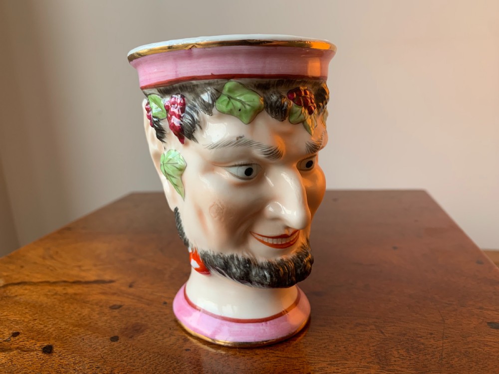 A set of four Victorian Staffordshire ceramic wine cups moulded in the form of bearded satyr faces with grapevine crowns and pink gilded rims. View XV