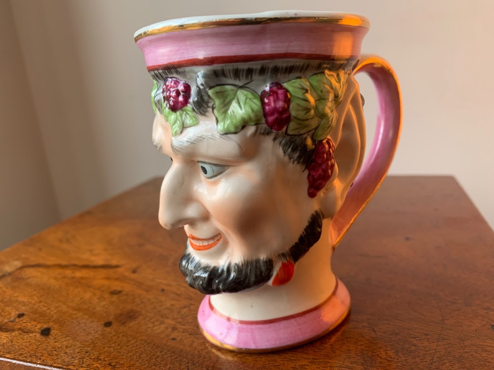 A set of four Victorian Staffordshire ceramic wine cups moulded in the form of bearded satyr faces with grapevine crowns and pink gilded rims. View XVI