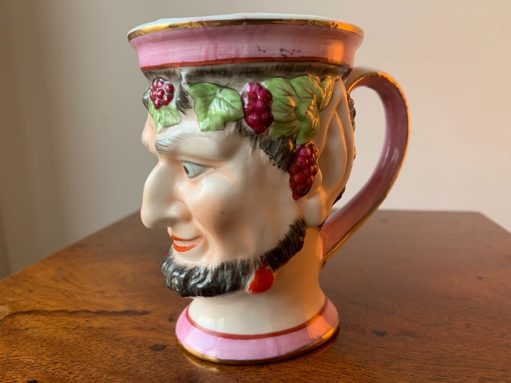 A set of four Victorian Staffordshire ceramic wine cups moulded in the form of bearded satyr faces with grapevine crowns and pink gilded rims. View XVII