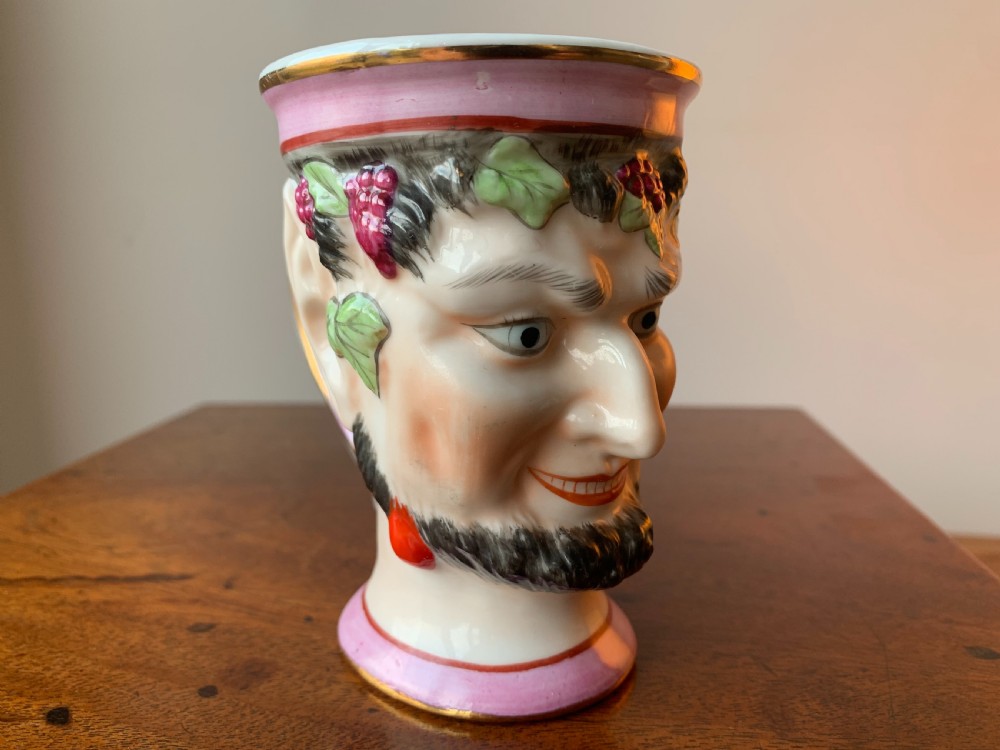 A set of four Victorian Staffordshire ceramic wine cups moulded in the form of bearded satyr faces with grapevine crowns and pink gilded rims. View XVIII