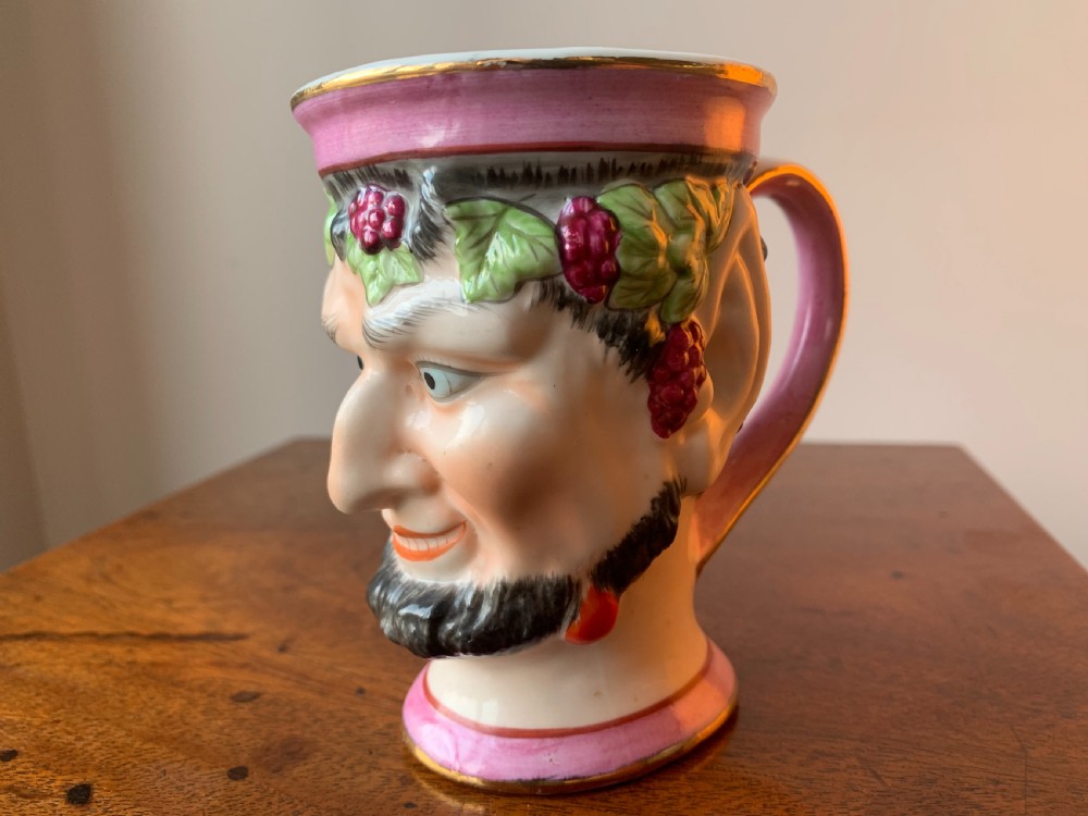 A set of four Victorian Staffordshire ceramic wine cups moulded in the form of bearded satyr faces with grapevine crowns and pink gilded rims. View XX