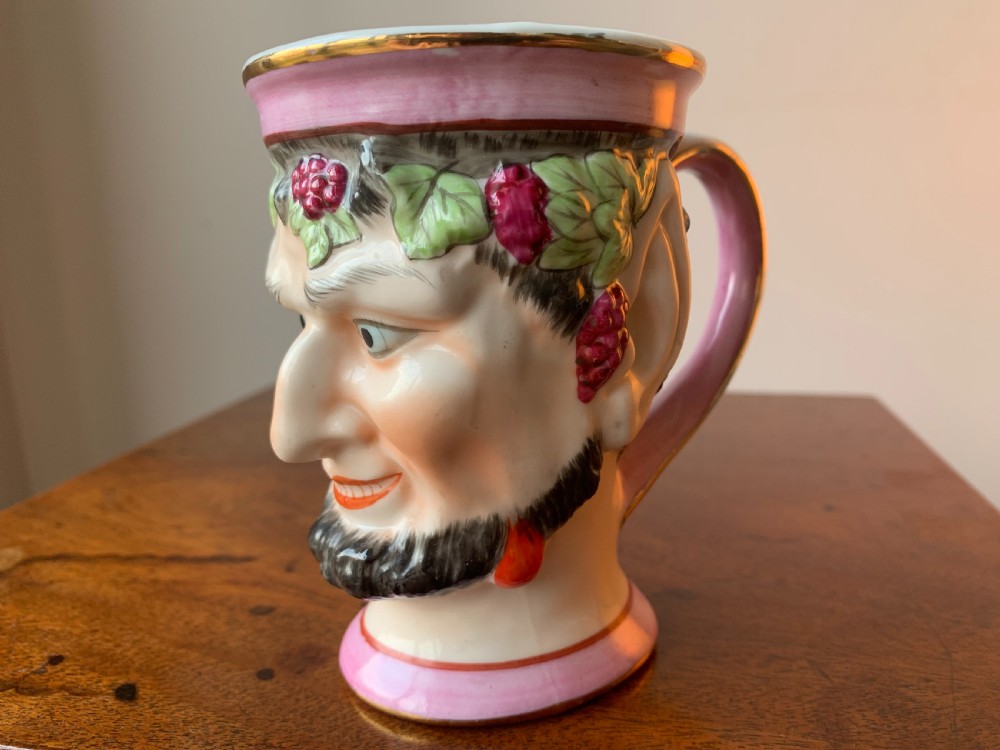 A set of four Victorian Staffordshire ceramic wine cups moulded in the form of bearded satyr faces with grapevine crowns and pink gilded rims. View XXI