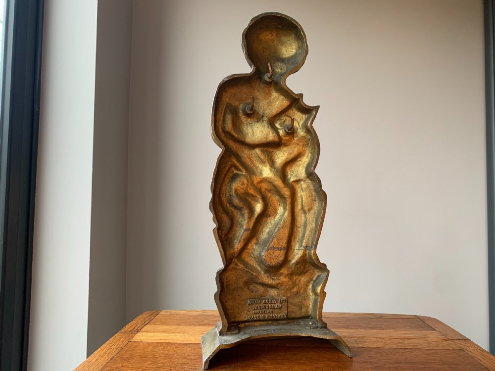 A gilded brass Art Deco sculptural companion set piece depicting a child holding a lamb atop a stepped geometric base. View V