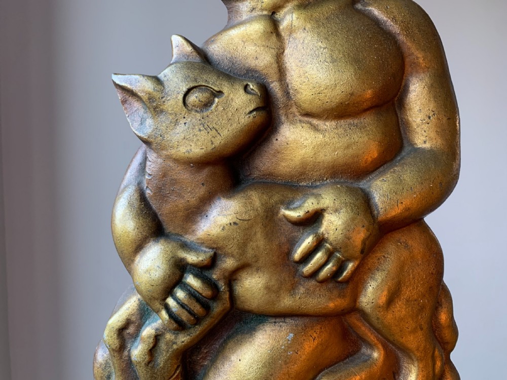 A gilded brass Art Deco sculptural companion set piece depicting a child holding a lamb atop a stepped geometric base. View VII