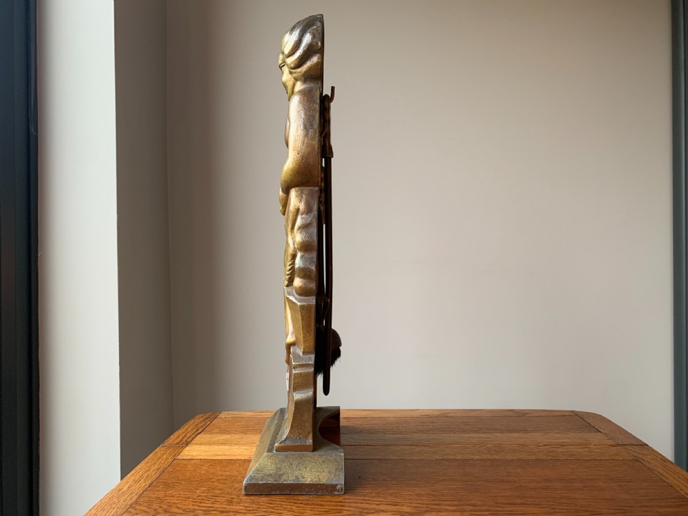 A gilded brass Art Deco sculptural companion set piece depicting a child holding a lamb atop a stepped geometric base. View VIII