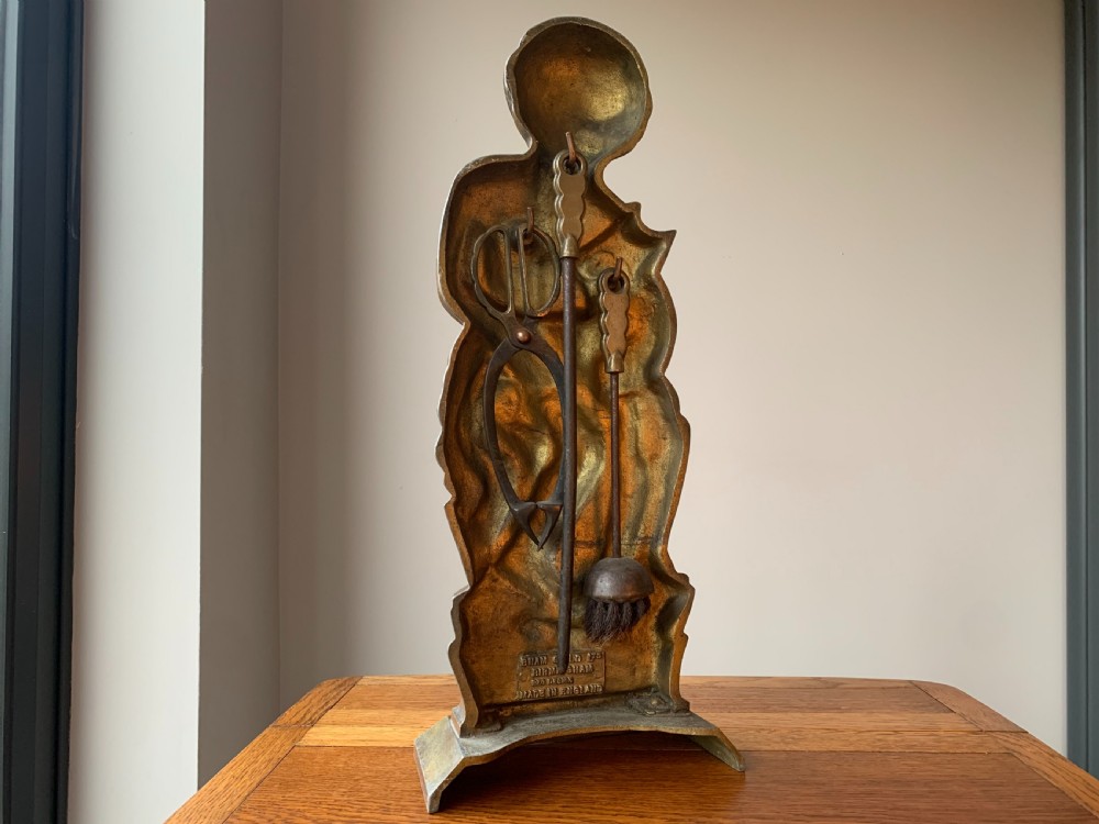 A gilded brass Art Deco sculptural companion set piece depicting a child holding a lamb atop a stepped geometric base. View IX