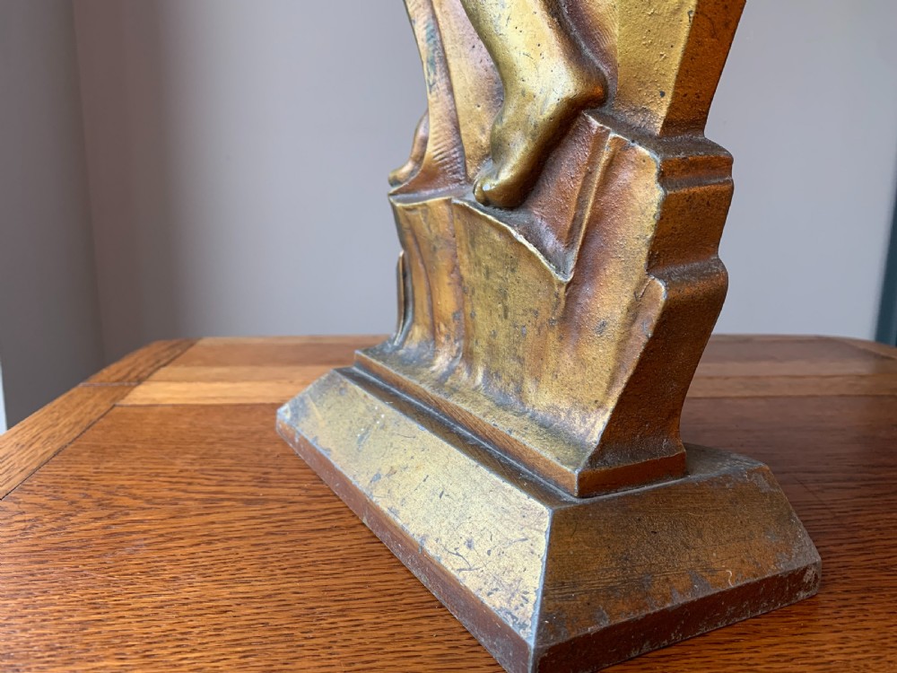 A gilded brass Art Deco sculptural companion set piece depicting a child holding a lamb atop a stepped geometric base. View XII