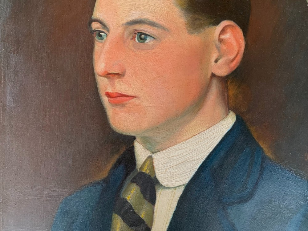 An unsigned Edwardian oil portrait on board depicting a young man in a blue jacket and striped tie, framed within an ornate carved giltwood frame. View III