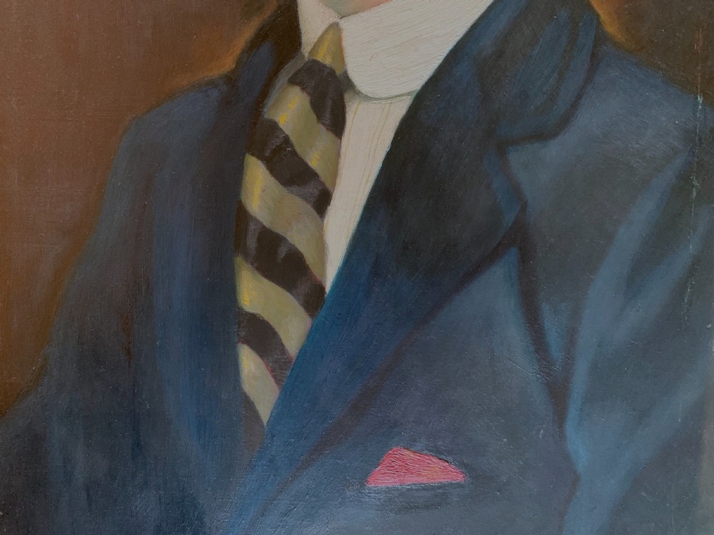 An unsigned Edwardian oil portrait on board depicting a young man in a blue jacket and striped tie, framed within an ornate carved giltwood frame. View V