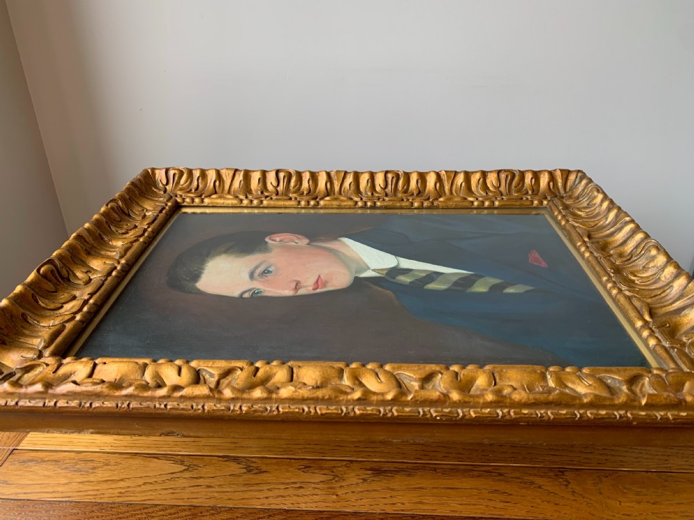 An unsigned Edwardian oil portrait on board depicting a young man in a blue jacket and striped tie, framed within an ornate carved giltwood frame. View VIII