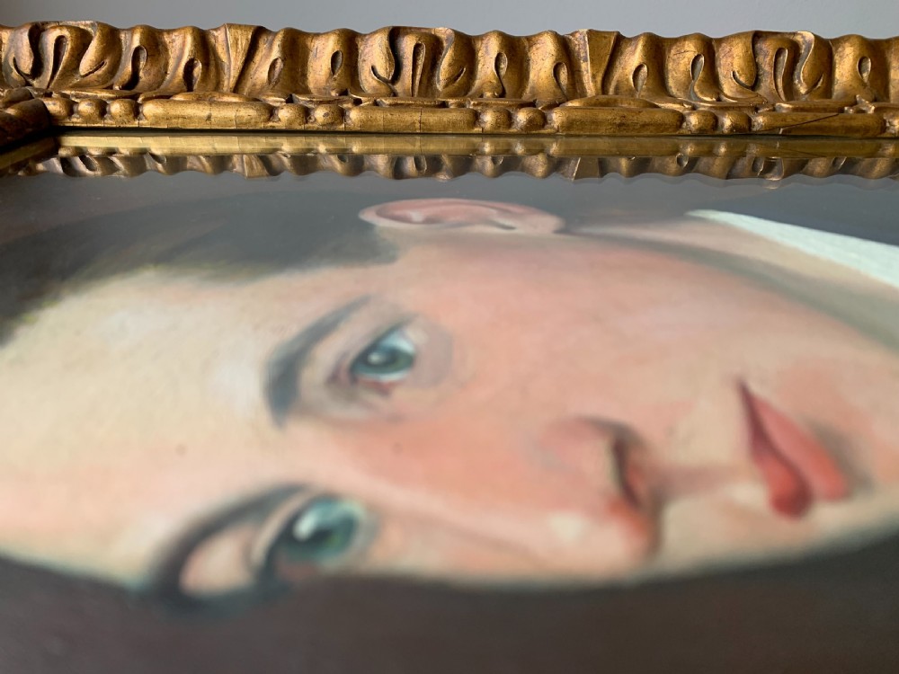 An unsigned Edwardian oil portrait on board depicting a young man in a blue jacket and striped tie, framed within an ornate carved giltwood frame. View IX