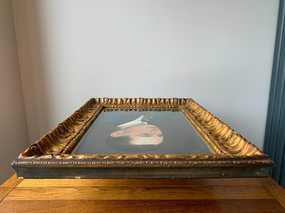 An unsigned Edwardian oil portrait on board depicting a young man in a blue jacket and striped tie, framed within an ornate carved giltwood frame. View XIII