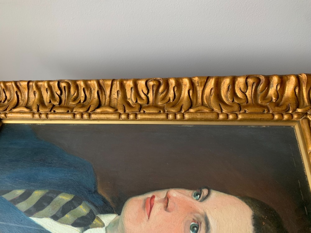 An unsigned Edwardian oil portrait on board depicting a young man in a blue jacket and striped tie, framed within an ornate carved giltwood frame. View XVI