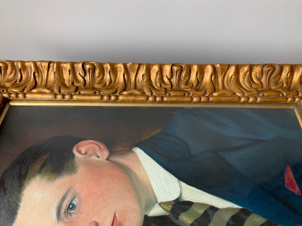 An unsigned Edwardian oil portrait on board depicting a young man in a blue jacket and striped tie, framed within an ornate carved giltwood frame. View XVII