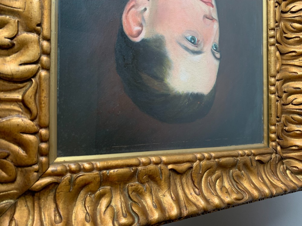 An unsigned Edwardian oil portrait on board depicting a young man in a blue jacket and striped tie, framed within an ornate carved giltwood frame. View XVIII