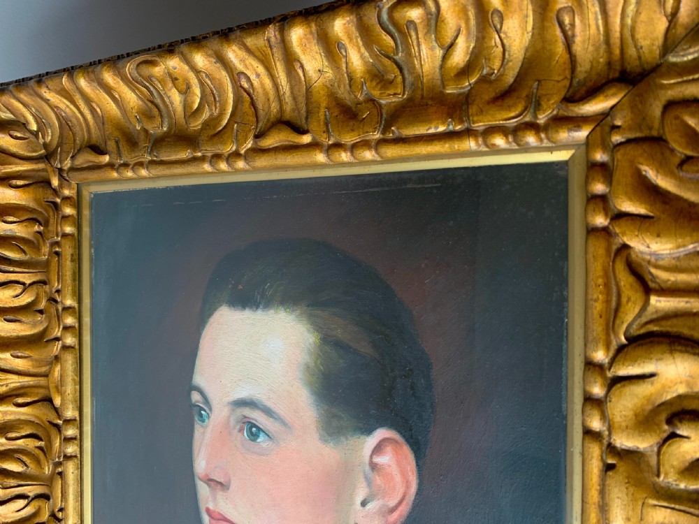 An unsigned Edwardian oil portrait on board depicting a young man in a blue jacket and striped tie, framed within an ornate carved giltwood frame. View XIX