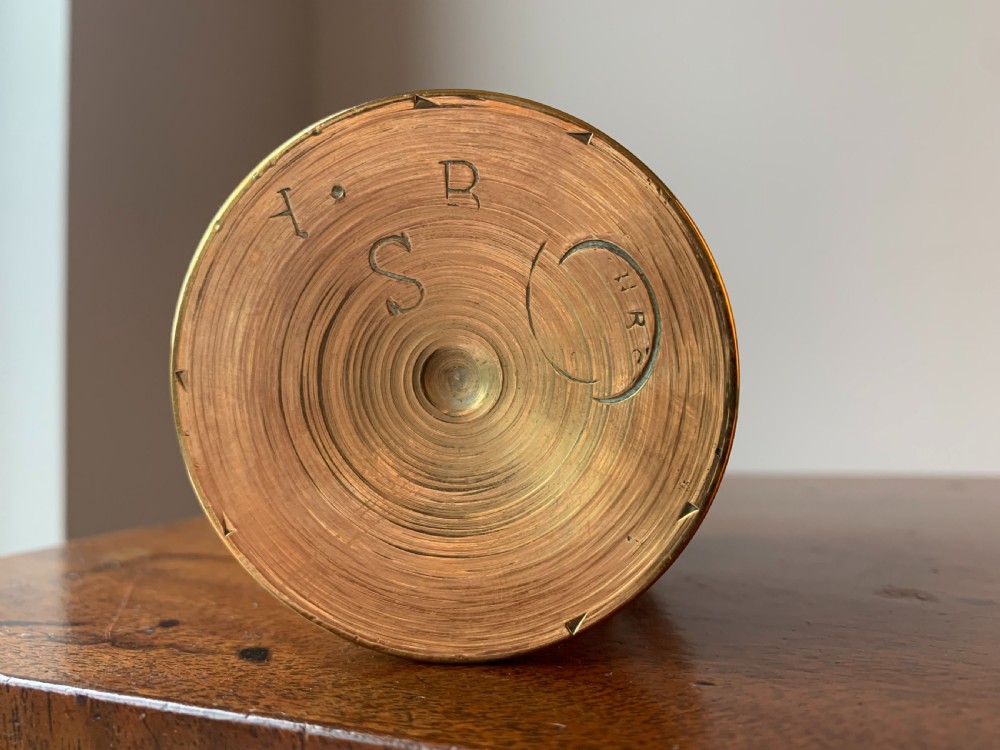 A heavy cast brass mortar with turned incised rings around the body, accompanied by a matching solid brass pestle. View V