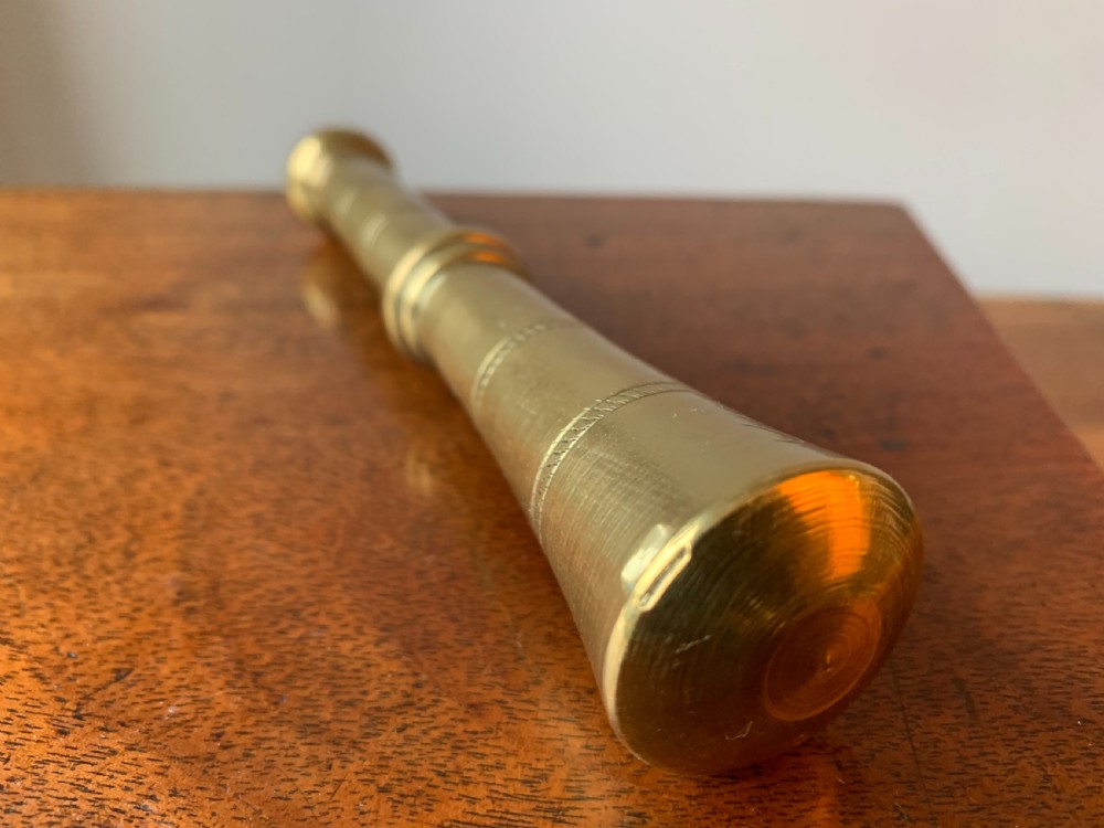 A heavy cast brass mortar with turned incised rings around the body, accompanied by a matching solid brass pestle. View VIII