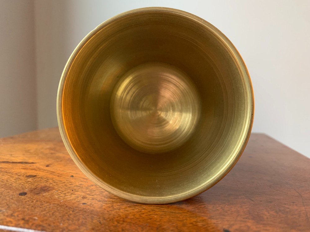 A heavy cast brass mortar with turned incised rings around the body, accompanied by a matching solid brass pestle. View XI