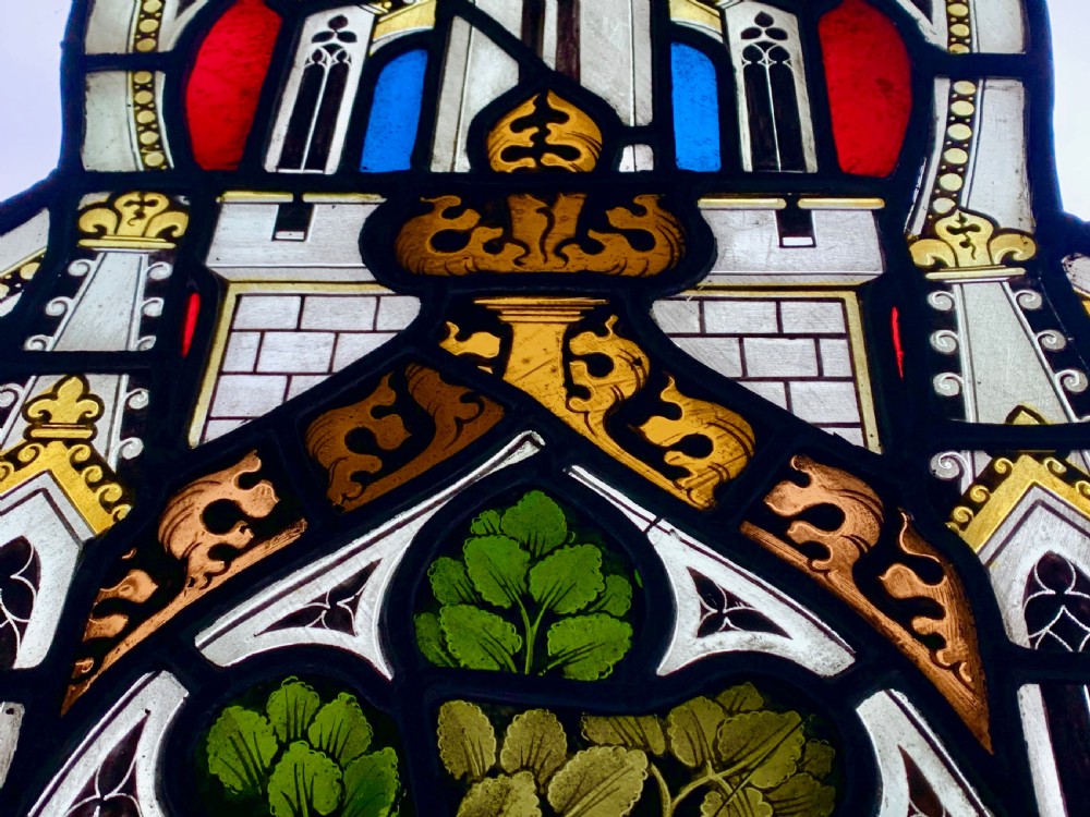 An arched Gothic Revival stained glass panel featuring painted architectural spires, foliate patterns, and lead cames in red, green, yellow, and clear glass. View II