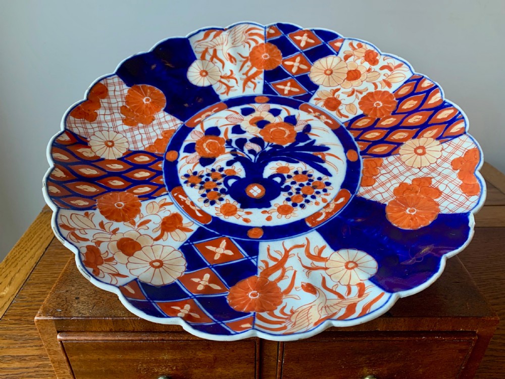 A nineteenth-century Japanese Imari porcelain charger featuring a scalloped rim, hand-painted in cobalt blue and iron-red floral and geometric brocade panels. View II