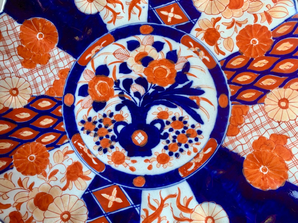 A nineteenth-century Japanese Imari porcelain charger featuring a scalloped rim, hand-painted in cobalt blue and iron-red floral and geometric brocade panels. View V