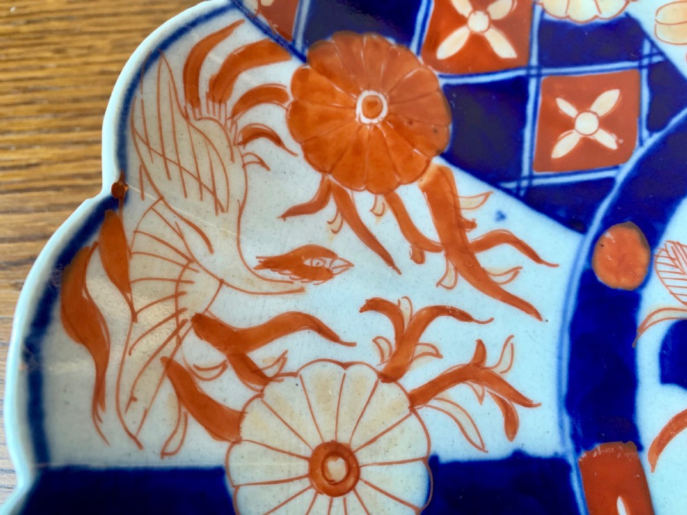 A nineteenth-century Japanese Imari porcelain charger featuring a scalloped rim, hand-painted in cobalt blue and iron-red floral and geometric brocade panels. View VII