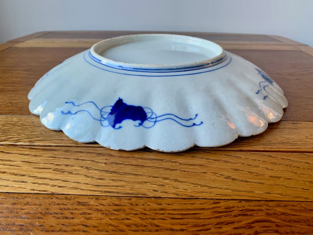 A nineteenth-century Japanese Imari porcelain charger featuring a scalloped rim, hand-painted in cobalt blue and iron-red floral and geometric brocade panels. View VIII