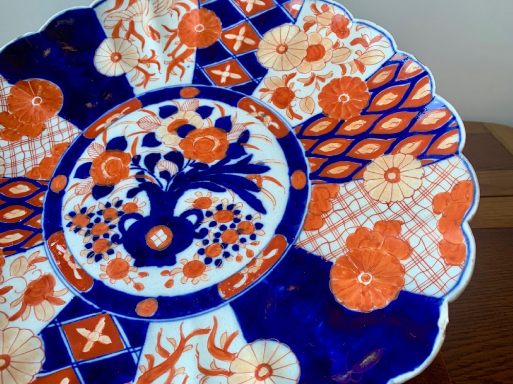 A nineteenth-century Japanese Imari porcelain charger featuring a scalloped rim, hand-painted in cobalt blue and iron-red floral and geometric brocade panels. View XII