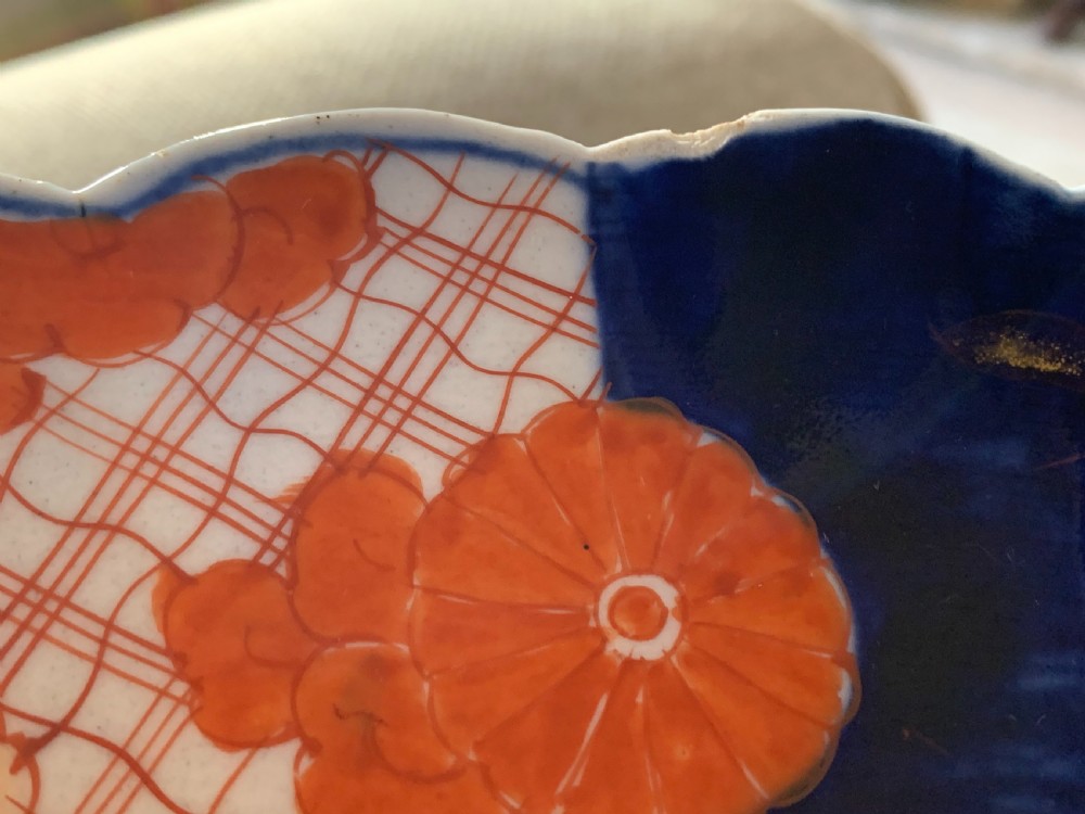 A nineteenth-century Japanese Imari porcelain charger featuring a scalloped rim, hand-painted in cobalt blue and iron-red floral and geometric brocade panels. View XVI