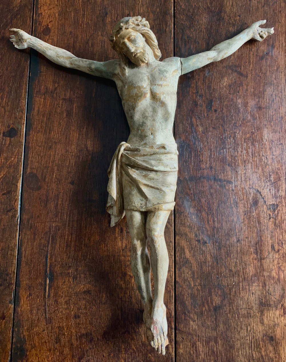 A 16th-century hand-carved lime wood Corpus Christi sculpture displaying remnant polychrome paint and gilding.