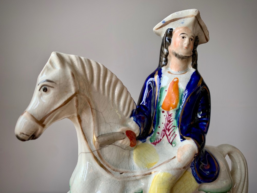 A Victorian Staffordshire pottery flatback figure depicting the highwayman Tom King on horseback wearing a tricorn hat and blue coat. View II