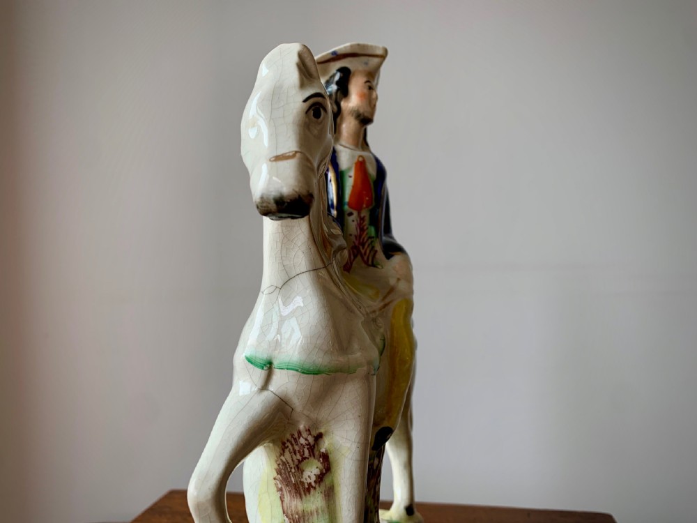 A Victorian Staffordshire pottery flatback figure depicting the highwayman Tom King on horseback wearing a tricorn hat and blue coat. View X