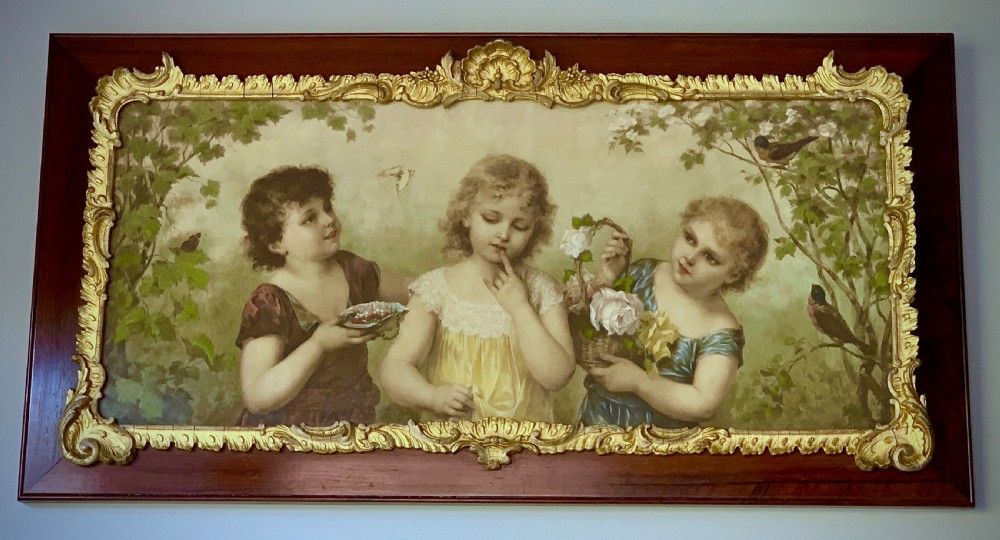 A horizontal Victorian print depicting three children in a garden setting, enclosed in a gilded Rococo-style inner frame set within a polished mahogany outer border.