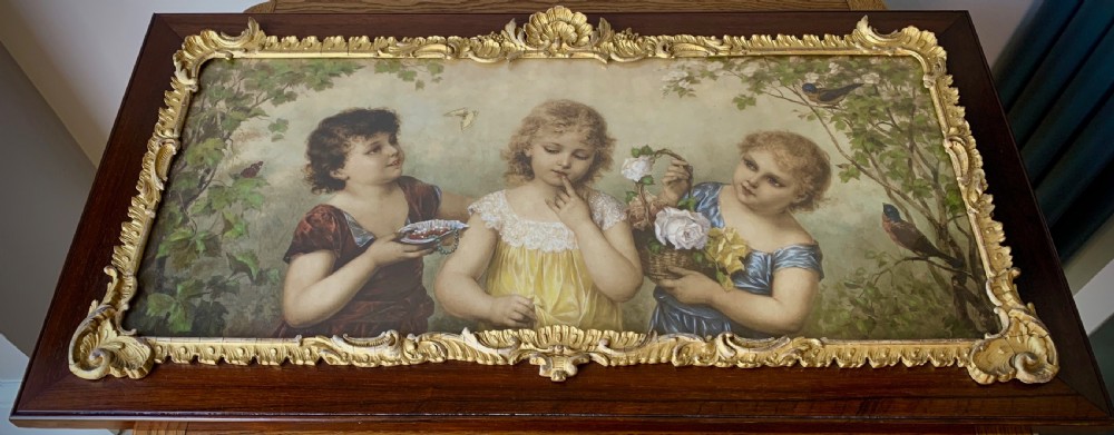 A horizontal Victorian print depicting three children in a garden setting, enclosed in a gilded Rococo-style inner frame set within a polished mahogany outer border. View II