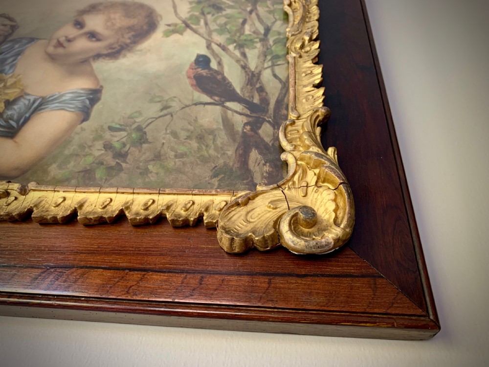 A horizontal Victorian print depicting three children in a garden setting, enclosed in a gilded Rococo-style inner frame set within a polished mahogany outer border. View XIII