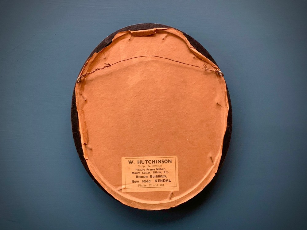 An oval framed miniature watercolour painting depicting a travelling musician wearing a blue tunic and feathered hat, surrounded by an ornate gilded and blue cartouche border. View VII
