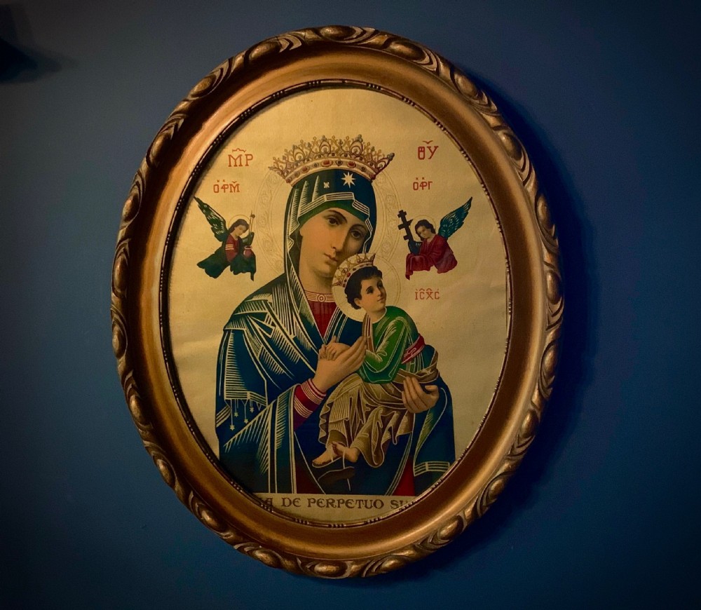 An oval gilt-framed Victorian print depicting the Virgin Mary holding the Christ Child flanked by angels in Byzantine iconographic style.