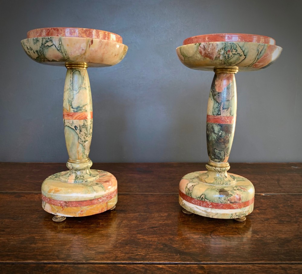 A pair of turned, variegated marble tazzas featuring shallow circular dishes raised on baluster stems and round bases in shades of red, green, and tan. View II
