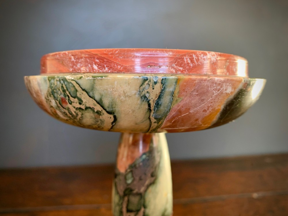 A pair of turned, variegated marble tazzas featuring shallow circular dishes raised on baluster stems and round bases in shades of red, green, and tan. View V