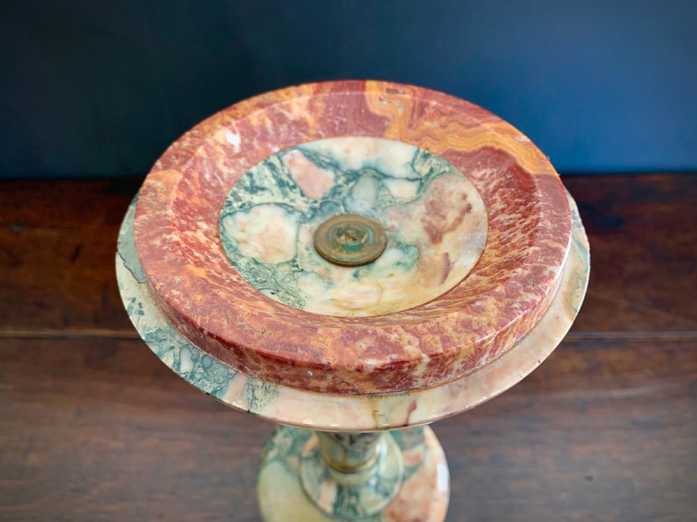 A pair of turned, variegated marble tazzas featuring shallow circular dishes raised on baluster stems and round bases in shades of red, green, and tan. View VI