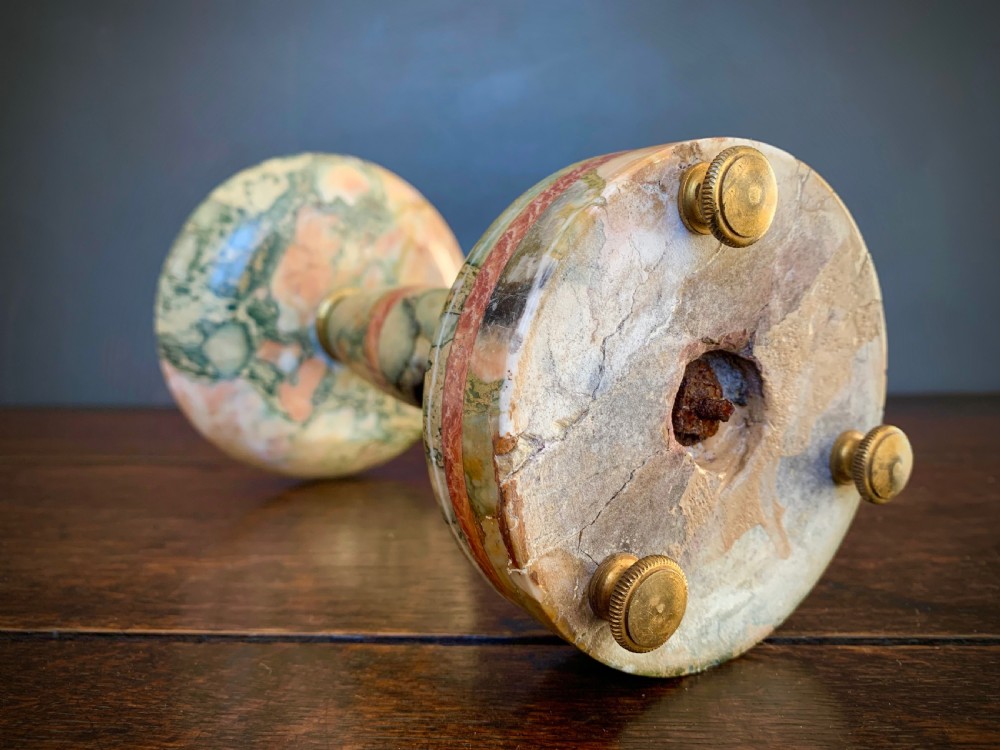A pair of turned, variegated marble tazzas featuring shallow circular dishes raised on baluster stems and round bases in shades of red, green, and tan. View VII