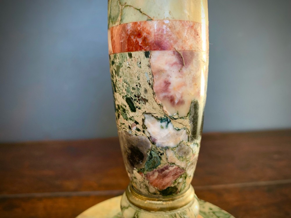 A pair of turned, variegated marble tazzas featuring shallow circular dishes raised on baluster stems and round bases in shades of red, green, and tan. View X