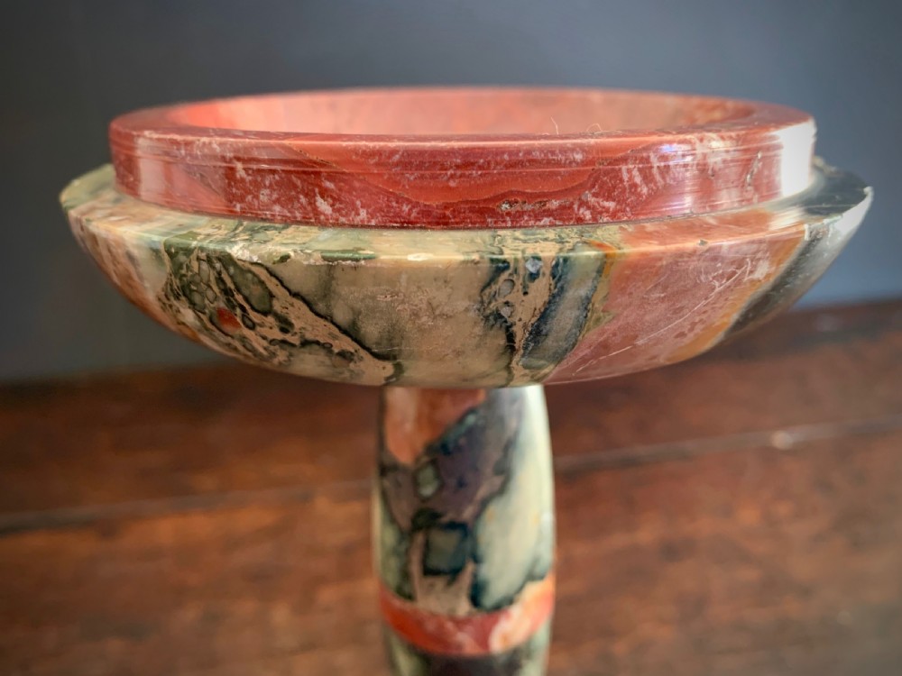 A pair of turned, variegated marble tazzas featuring shallow circular dishes raised on baluster stems and round bases in shades of red, green, and tan. View XX
