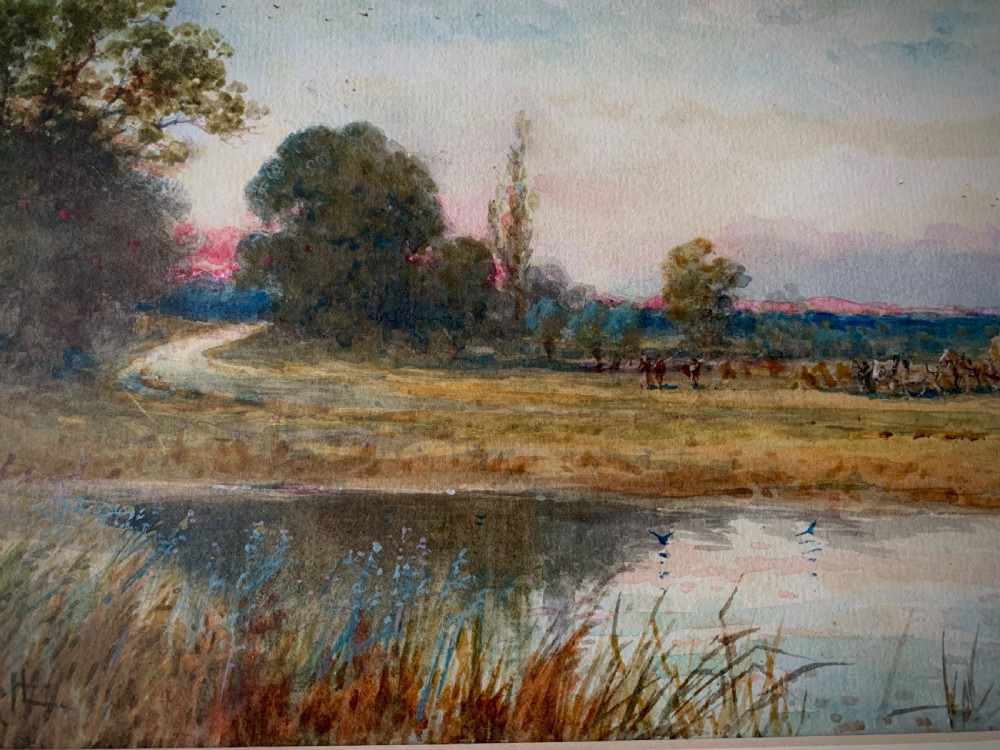 A framed 19th-century watercolour painting depicting a serene rural sunset landscape with a calm river, trees, and fields. View III