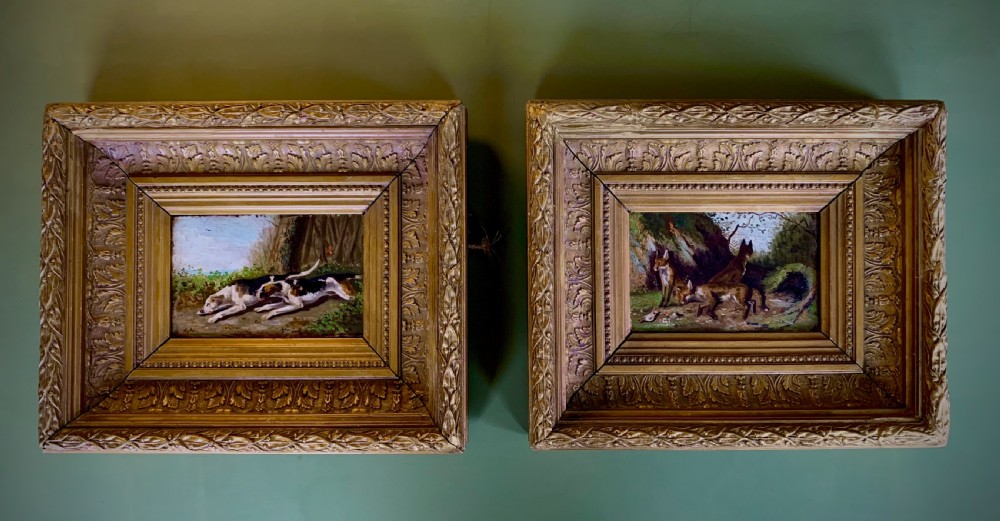 Pair of 19th-century English oil paintings on board depicting hunting hounds and foxes in deep gilt frames.