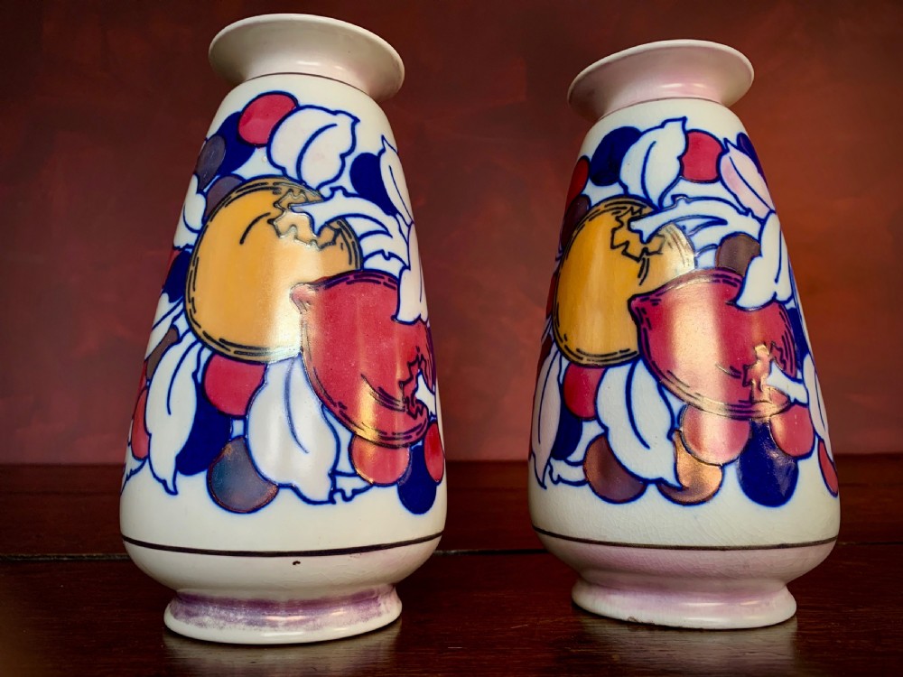 A pair of Art Deco earthenware vases featuring tubelined fruit motifs with iridescent lustre glazing on a cream background. View II