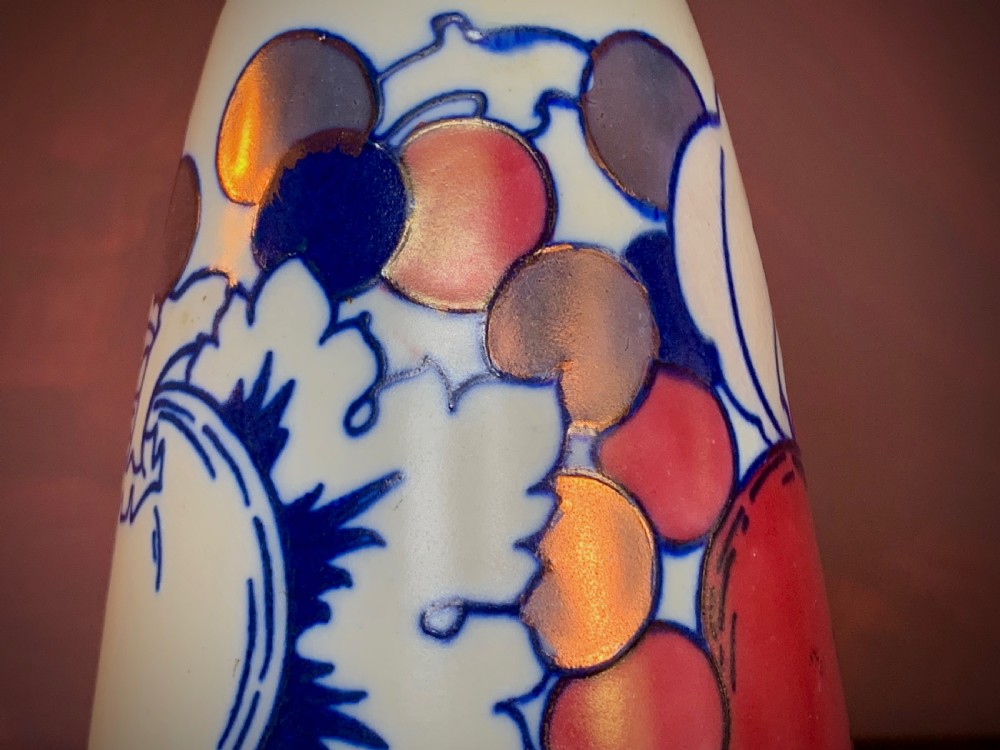 A pair of Art Deco earthenware vases featuring tubelined fruit motifs with iridescent lustre glazing on a cream background. View III
